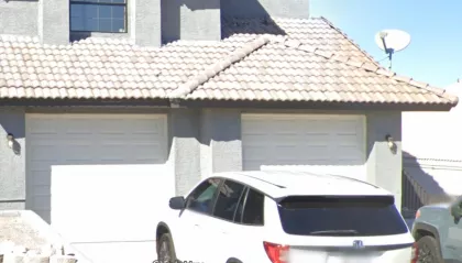 Bee removal inspection in progress on a stucco garage wall in Bullhead City